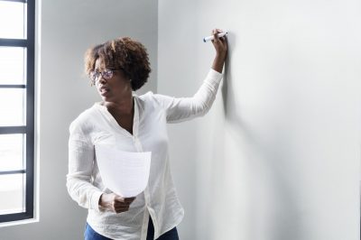 Teacher instructing a class from the whiteboard.